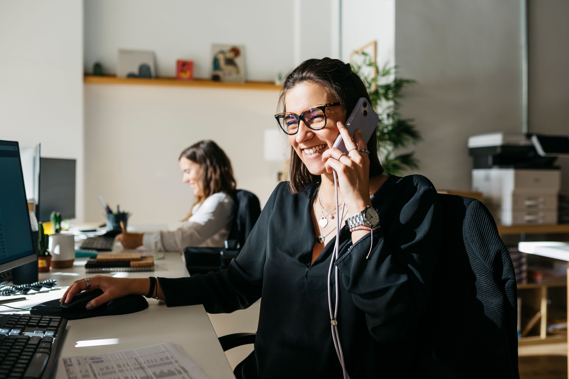 Business woman talking on the phone, communicating with her clients as she works in an office